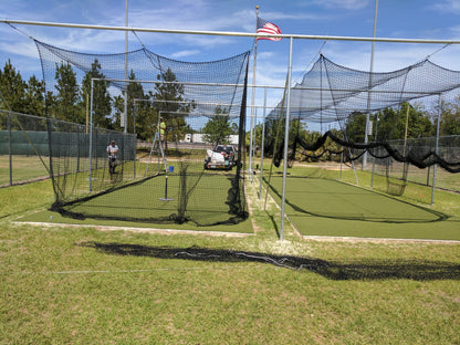 A baseball field with many batting cages in it