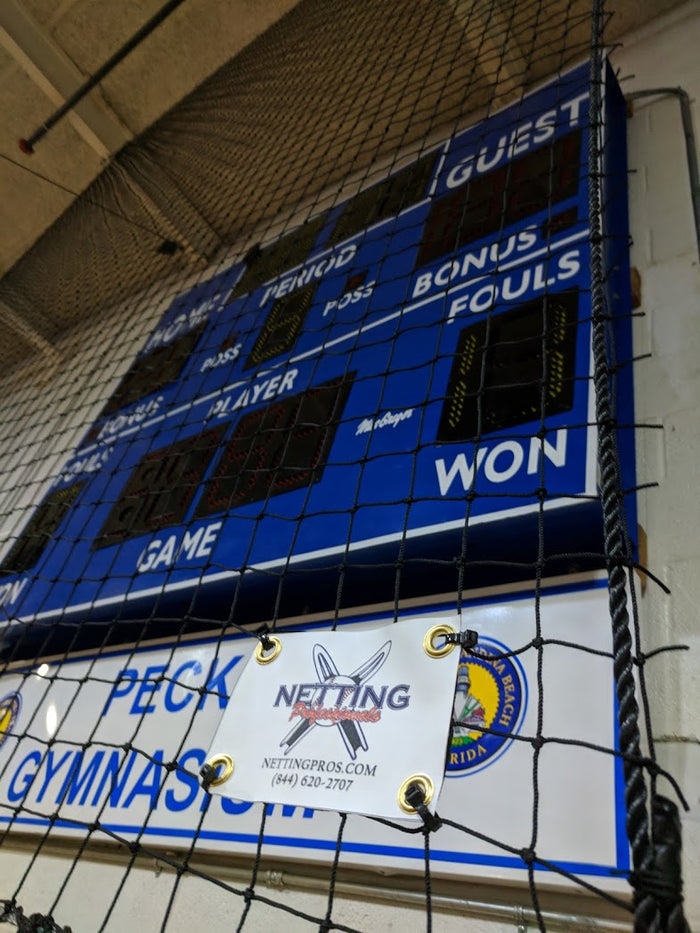A large blue scoreboard in the middle of an indoor arena.